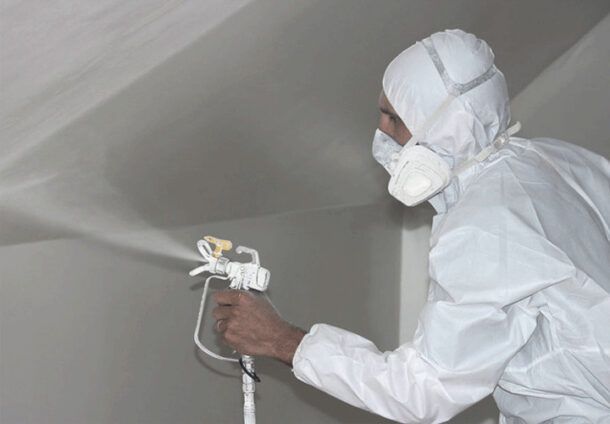 Процесс нанесения побелки на поверхность стен и потолка с применением распылителя и пылесоса